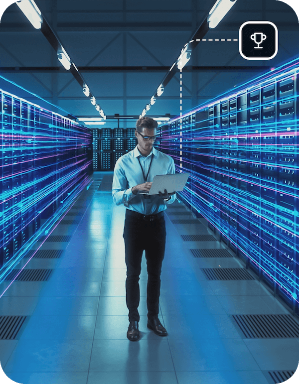 A man is standing in a server room with an open laptop, with lights behind him to indicate fast server speeds similar to what is offered by Eweka Internet Services.