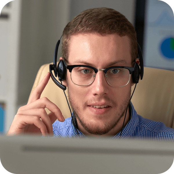 A male customer service agent with eyeglasses is wearing a wired headset, talking to an Eweka user, and assisting them.