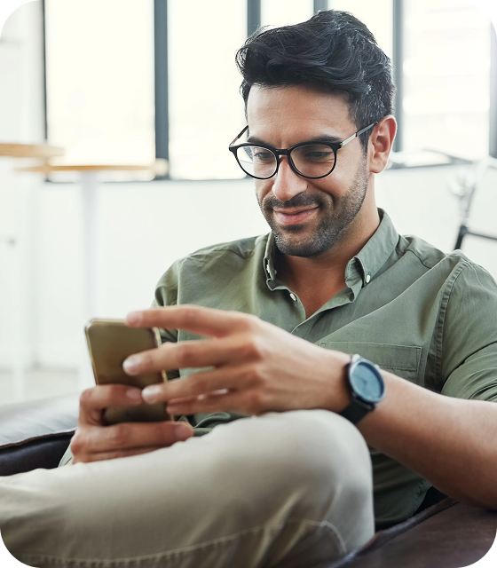 A man wearing glasses is sitting in an office, connecting to a secure VPN on his cell phone