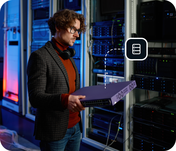 A man wearing glasses stands in a server room holding a piece of equipment, symbolizing the speed and security offered by the Usenet servers hosted by Eweka.