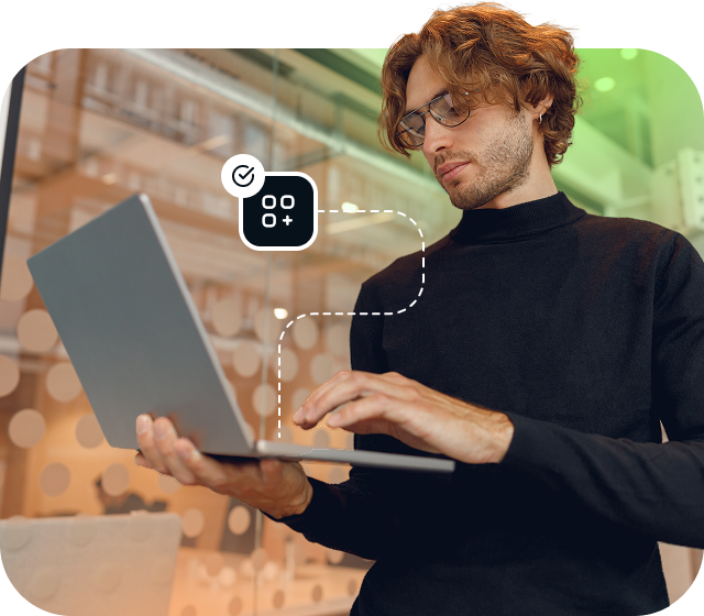 Ein Mann im Rollkragenpullover und mit Brille steht mit einem offenen Laptop und greift mit Eweka auf Usenet zu, um das beste Usenet-Erlebnis zu erhalten.