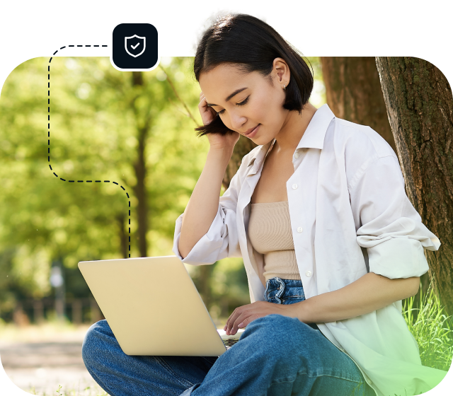 A woman in a white shirt is sitting outside using a laptop to access Eweka Internet Services, the best Usenet provider.