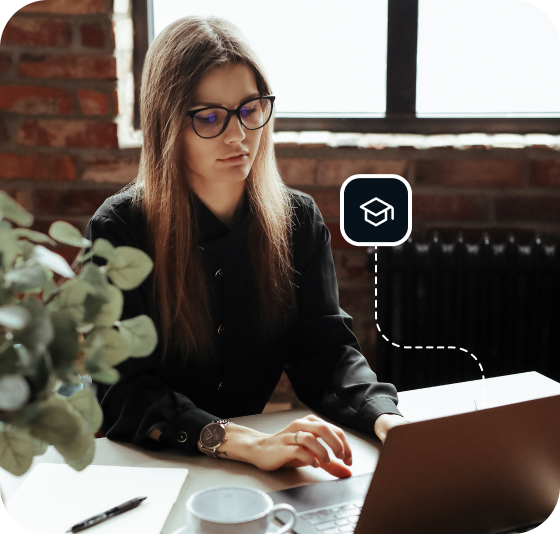 Een vrouw in een zwart overhemd met zwarte cat-eye-bril bladert door Usenet op haar laptop.