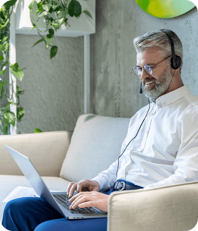Een mannelijke klantenservicemedewerker typt op een laptop en praat met een Eweka-gebruiker via een bedrade headset, waarmee wordt aangetoond dat Eweka 24/7 klantenondersteuning biedt.