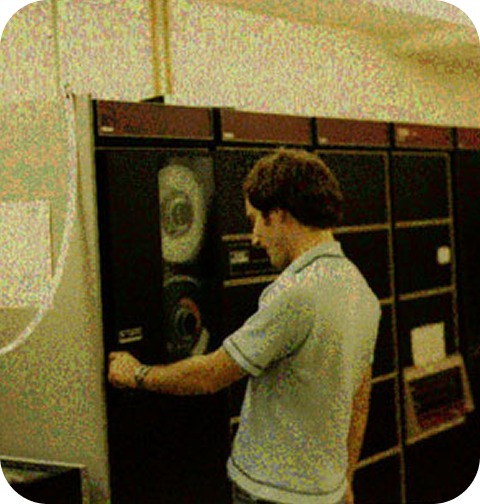 Tom Truscott at Duke University in the late 1970s, making adjustments to a reel-to-reel computer.